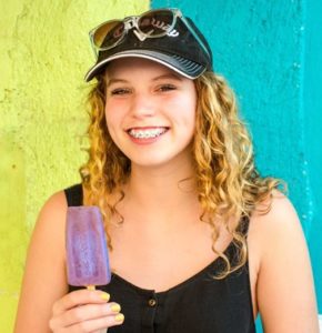 Young woman with braces and a popsicle 